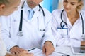 Doctor and patient talking while sitting at the desk in office. Physician pointing into medical history form. Medicin Royalty Free Stock Photo