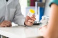 Doctor, patient and urine test cup. Physician giving pee container to a woman in clinic or hospital emergency room. Royalty Free Stock Photo