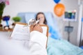 Doctor, patient and writing on clipboard in a hospital with a sick woman in bed for a report. Healthcare, medical staff Royalty Free Stock Photo