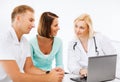 Doctor with patients looking at laptop