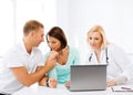 Doctor with patients looking at laptop