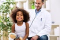 Doctor pediatrician examining cute smiling african girl Royalty Free Stock Photo