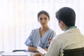 Doctor with pen and stethoscope sitting in office while talking about problem health patient woman fell friendly