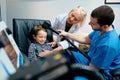 Paediatrician Doctor Doing Brain Treatment To Autistic Child In Clinic