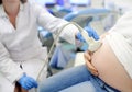 Doctor performing ultrasound on pregnant woman on clinic. Medical insurance childbearing. Family doctor for gestation. Maternity Royalty Free Stock Photo