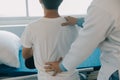 Doctor Or Physical Therapist Examines Back Pain And Spinal Area To Give Advice Within The Rehabilitation Center
