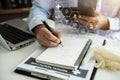 Doctor physician or practitioner in lab room writing on blank notebook and work on laptop computer. Royalty Free Stock Photo