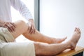 Doctor physiotherapist assisting a male patient while giving exercising treatment massaging the leg of patient in a physio room,