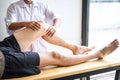 Doctor or Physiotherapist working examining treating injured leg of athlete male patient, Doing the Rehabilitation therapy pain in Royalty Free Stock Photo