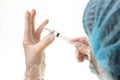 The doctor picks up the drug from the ampoule with a syringe, close-up