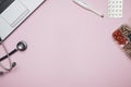 Doctor pink desk table with stethoscope, medicine, notebook. Top view with copy space, flat lay.