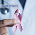 Doctor with a pink ribbon and text cancer research Royalty Free Stock Photo