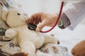 Doctor playfully checking the heart beat of a teddy bear Royalty Free Stock Photo