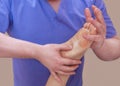 The doctor-podiatrist does an examination and massage of the patient`s foot Royalty Free Stock Photo