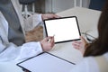 Doctor pointing at digital tablet screen and explaining diagnosis to her female patient. Royalty Free Stock Photo