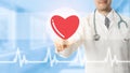Doctor pointing at heart icon on blue background