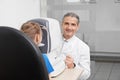 Doctor posing, testing eye of patient with eye test machine. Royalty Free Stock Photo