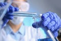 Doctor pouring blue liquid into flask. Laboratory analysis