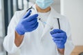 Doctor in PPE holding a vial or bottle vaccine against coronavirus Covid 19 new Omicron variant or strain in his hand, close up. Royalty Free Stock Photo