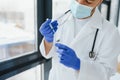 Doctor in PPE holding a vial or bottle vaccine against coronavirus Covid 19 new Omicron variant or strain in his hand, close up. Royalty Free Stock Photo