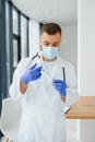 Doctor in PPE holding a vial or bottle vaccine against coronavirus Covid 19 new Omicron variant or strain in his hand, close up. Royalty Free Stock Photo