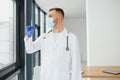 Doctor in PPE holding a vial or bottle vaccine against coronavirus Covid 19 new Omicron variant or strain in his hand, close up. Royalty Free Stock Photo