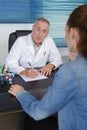 Doctor prescribing medicine to young patient in office Royalty Free Stock Photo