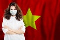 Doctor in protective face mask against national flag Vietnam. Flu epidemic and virus protection concept