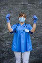 Doctor in protective gloves and mask holding red test tube on abstract background Royalty Free Stock Photo