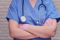 A doctor in protective gloves with a stethoscope stands with his arms crossed, close-up Royalty Free Stock Photo