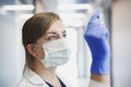 Doctor in protective mask with an ampule in hand