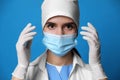 Doctor in protective mask and medical gloves against blue background Royalty Free Stock Photo