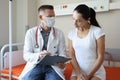 Doctor in protective medical mask communicates with patient in hospital Royalty Free Stock Photo