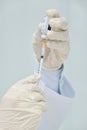 A doctor pulling up the serum vaccine from the medicine pack bottle with a syringe