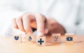 Doctor pushing wooden block cube which print screen health care and medical icons for healthy and wellness concept