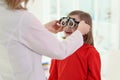 Doctor puts ophthalmology goggles on girl to check eyesight