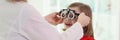 Doctor puts ophthalmology goggles on girl to check eyesight
