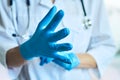 Doctor puts on rubber gloves.  on a light blue background Royalty Free Stock Photo