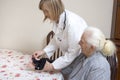 Doctor puts the stabilizer on the wrist of the old woman. Royalty Free Stock Photo