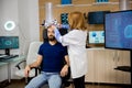 Doctor putting brainwaves scanning headset on male patient