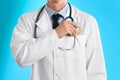 Doctor putting bribe into pocket on blue background, closeup. Corruption in medicine Royalty Free Stock Photo