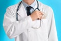 Doctor putting bribe into pocket on blue background, closeup. Corruption in medicine Royalty Free Stock Photo