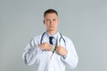 Doctor putting bribe into pocket on grey. Corruption in medicine Royalty Free Stock Photo