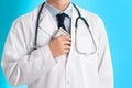 Doctor putting bribe into pocket on light background, closeup. Corruption in medicine Royalty Free Stock Photo