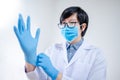 Doctor putting disposable latex gloves on hand Royalty Free Stock Photo