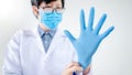 Doctor putting disposable latex gloves on hand Royalty Free Stock Photo