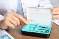 Doctor putting hearing aid into box at table, closeup Royalty Free Stock Photo