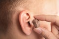 Doctor putting hearing aid in patient`s ear Royalty Free Stock Photo