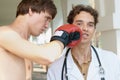 Doctor receiving a punch from angry boxer Royalty Free Stock Photo