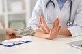 Doctor rejecting bribe in clinic. Corrupted medicine Royalty Free Stock Photo